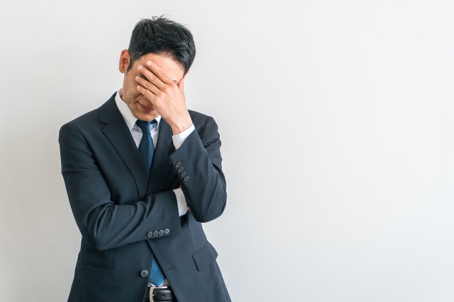 退職代行が企業にとって迷惑であるということを伝えるための、迷惑そうに悩んでいる男性の画像